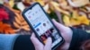 Shutterstock -- Woman holds smartphone with Instagram profile on the screen, social media, photos, storis, generic, undated